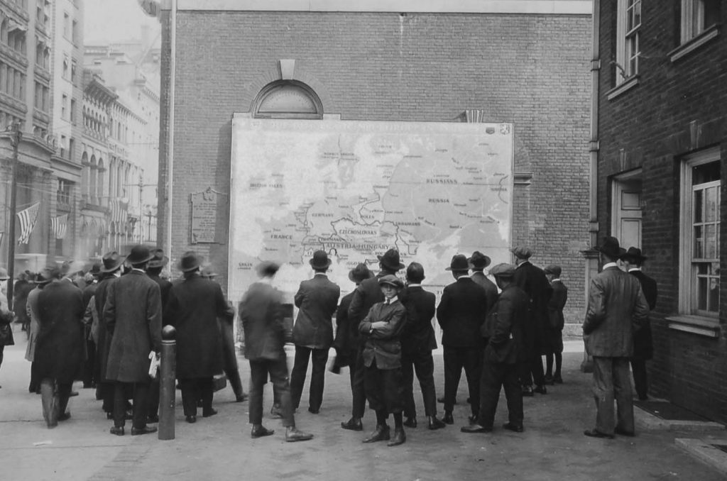 People gathered around a map of Europe to look at the new borders following the end of WW1