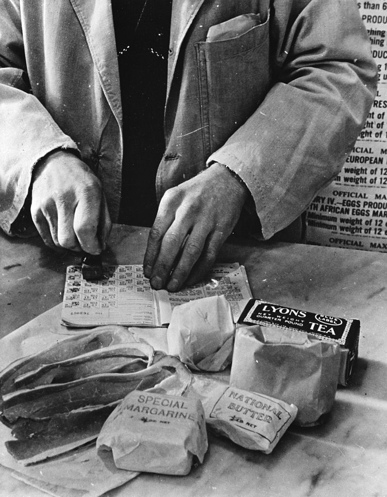 A shopkeeper is cancelling a ration book during World War 2.