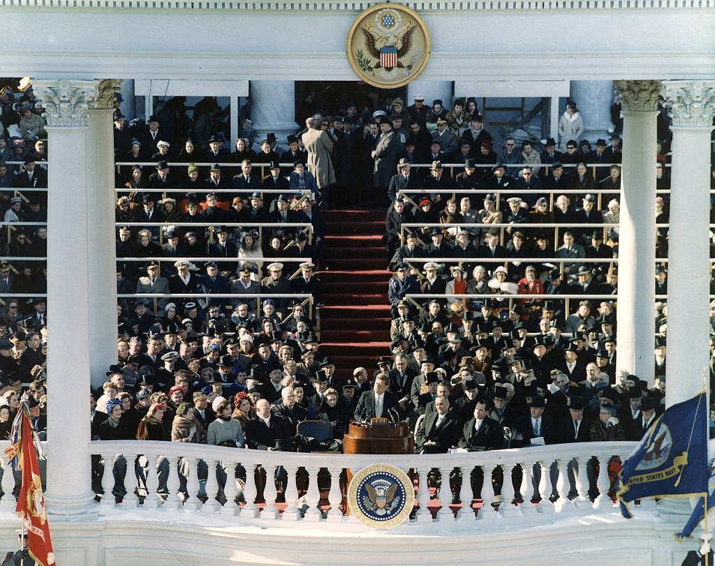John F Kennedy, President of the United States, saying his inaugural address during his inauguration at Washington, DC on January 20th 1961. He is surrounded by man others.