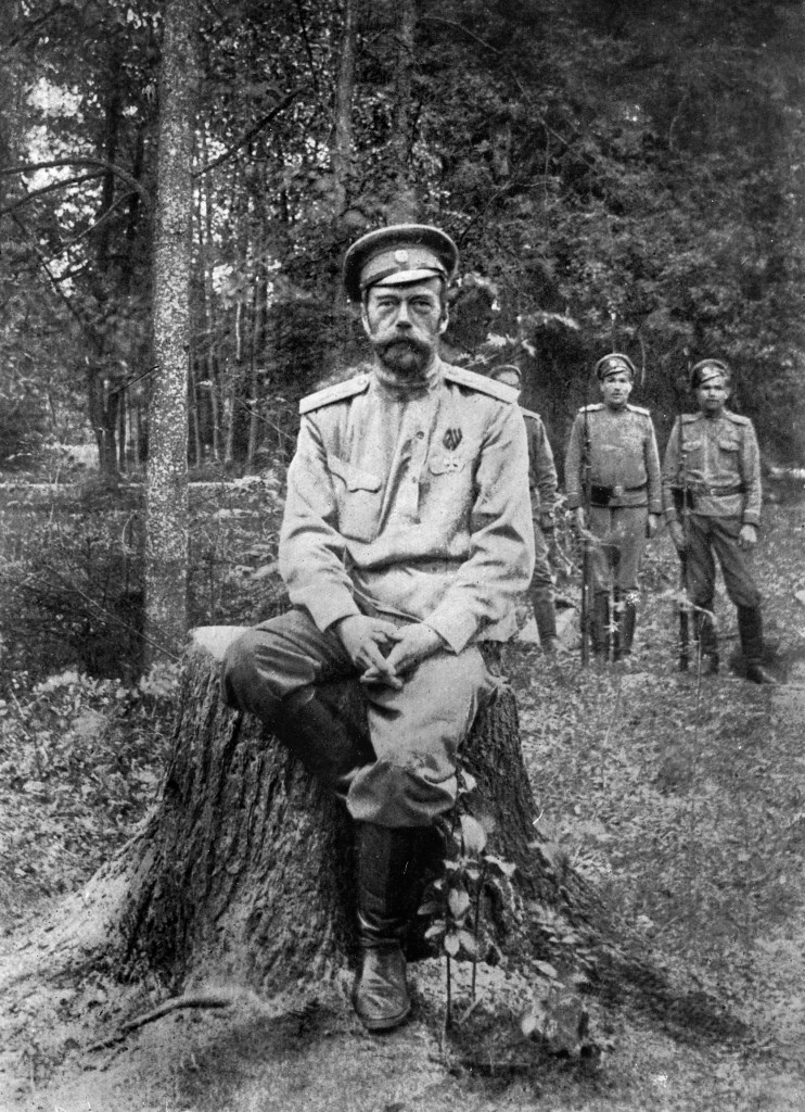 Nicholas II photographed sitting on a tree stump with guards behind him in 1917 it is believed to be his last photo.