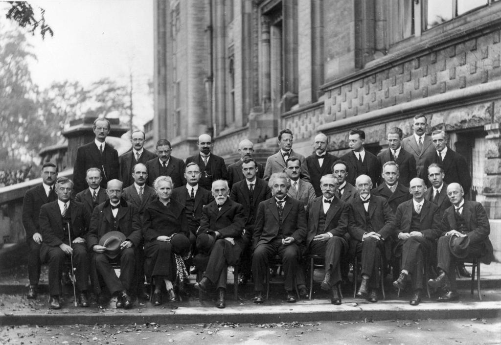 Key attendees of the 1927 Solvay conference photographed sitting down and in suits. The names are Auguste Piccard, Émile Henriot, Paul Ehrenfest, Édouard Herzen, Théophile de Donder, Erwin Schrödinger, Jules-Émile Verschaffelt, Wolfgang Pauli, Werner Heisenberg, Ralph Howard Fowler, Léon Brillouin,
Peter Debye, Martin Knudsen, William Lawrence Bragg, Hendrik Anthony Kramers, Paul Dirac, Arthur Compton, Louis de Broglie, Max Born, Niels Bohr,
Irving Langmuir, Max Planck, Marie Skłodowska Curie, Hendrik Lorentz, Albert Einstein, Paul Langevin, Charles Eugène Guye, Charles Thomson Rees Wilson, Owen Willans Richardson