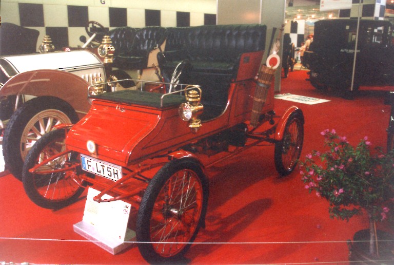 A red Stanley Steamer steam car from 1900 - 1906 on display at a museum.