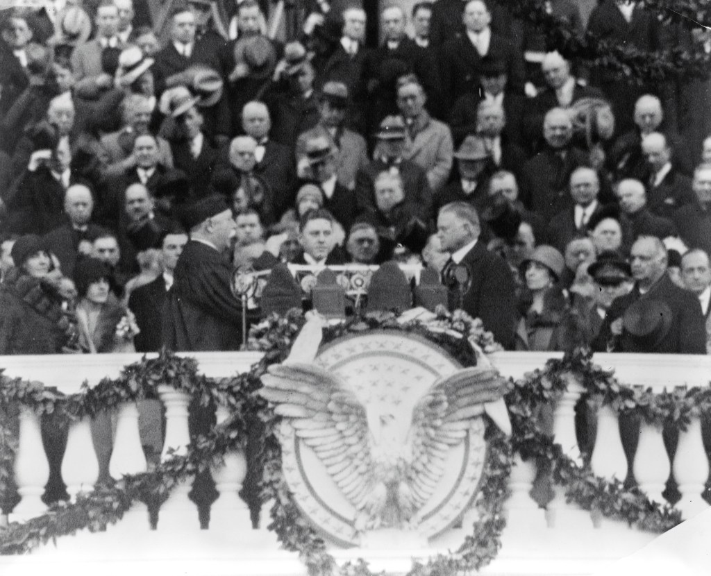 Herbert Hoover at his inauguration doing the oath of office which is being administered by Chief Justice Taft, who was also a US President. They are surrounded by a crowd. 1929.