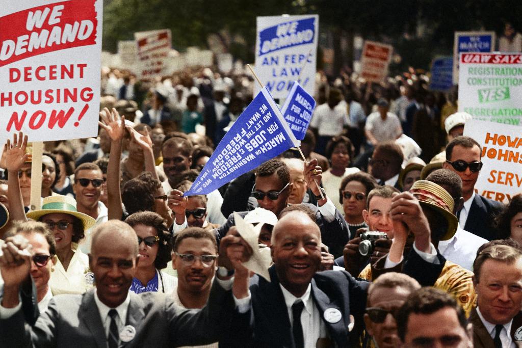 Leaders of the march on washington leading marchers down the street. This photograph has been colorized.