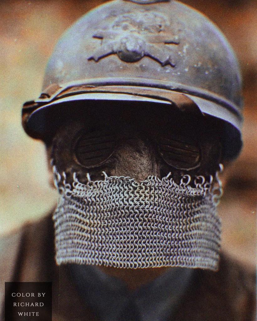 Color photograph of a French soldier wearing a WWI tank chainmail splatter mask