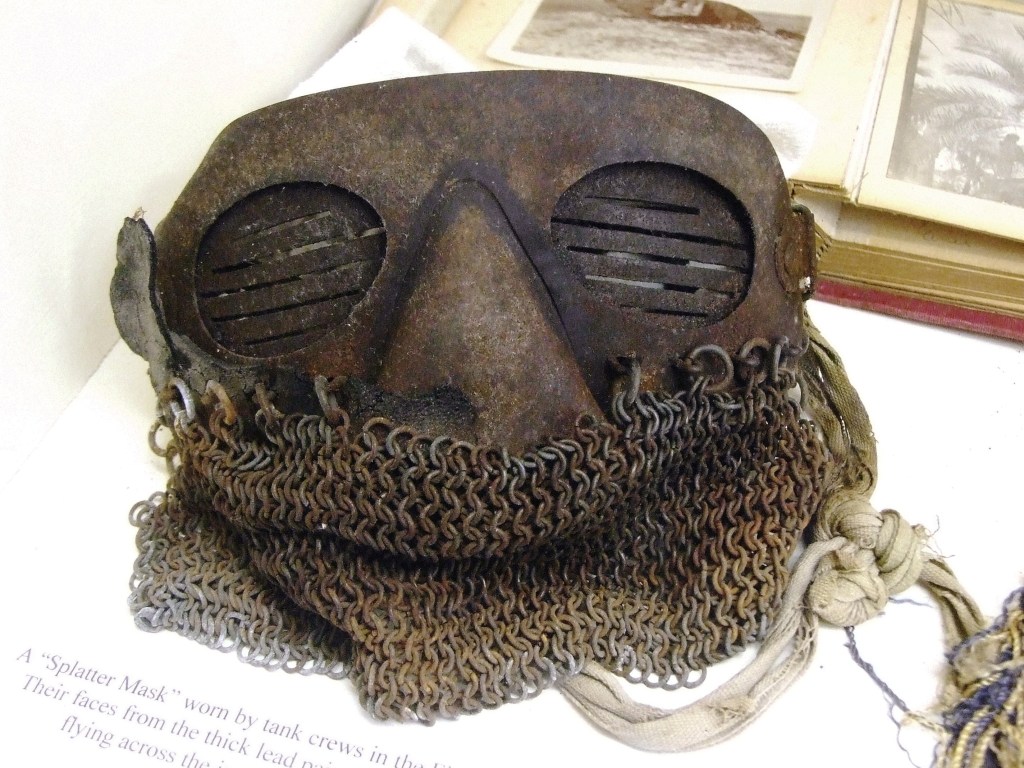 Chainmail splatter mask on display at a museum.