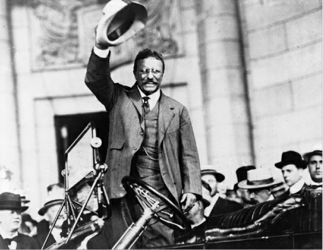 Theodore Roosevelt in an automobile holding a hat in Washington, DC in 1914.