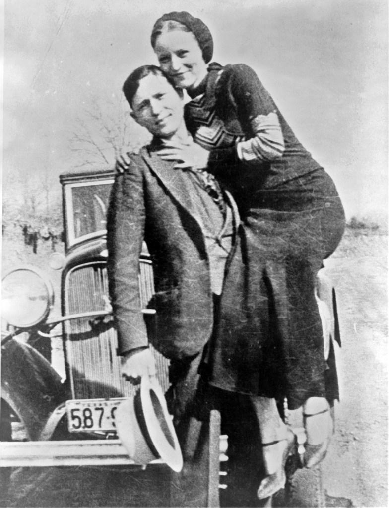 Bonnie and Clyde photographed together in front of a car