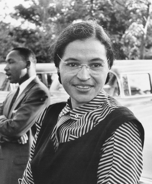 Martin Luther King Jr standing behind Rosa Parks in 1955