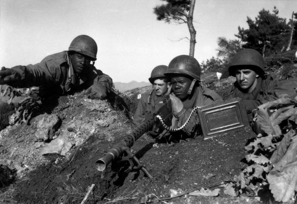Fighting with the 2nd Inf. Div. north of the Chongchon River, Sfc. Major Cleveland, weapons squad leader, points out Communist-led North Korean position to his machine gun crew. November 20,1950. Pfc. James Cox.