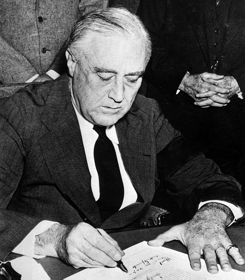 United States President Franklin D. Roosevelt signing the declaration of war against Japan, in the wake of the attack on Pearl Harbor.