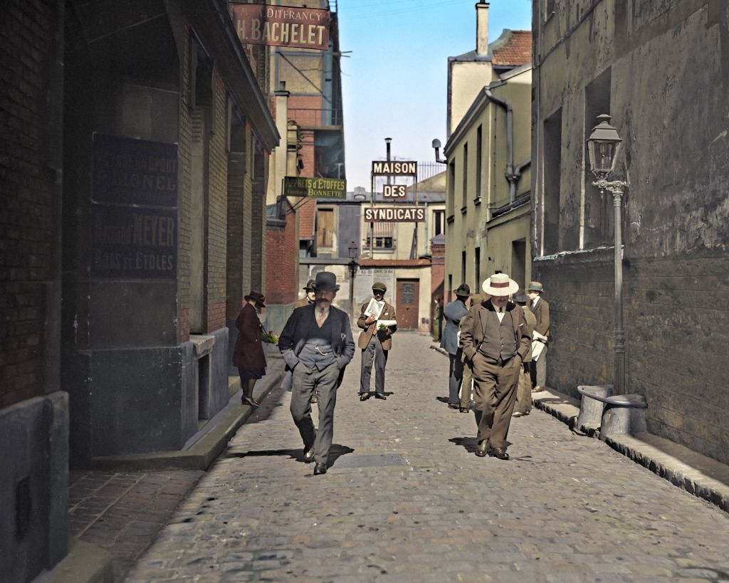 People photographed in May 1921 on Impasse Chausson, a street in Paris, France facing the 'Maison Des Syndicats' which is the Paris Trade Union House. Colorized by Baptiste Pierre