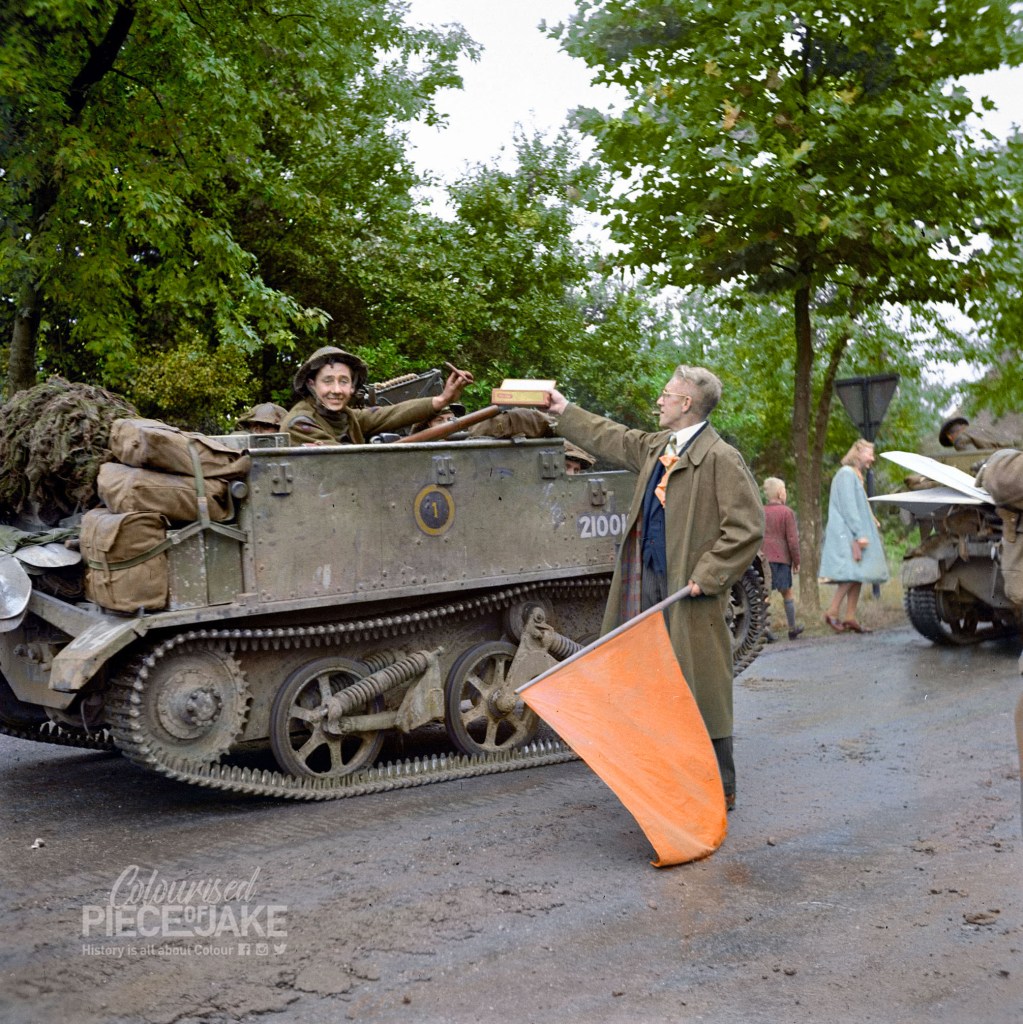 Colorized Photograph by Jakob Lagerweij of a soldier receiving a cigar from a resident of the village of Aalst during World War 2. Colorized for the book series World War 2 in Color (WO2 in Kleur)