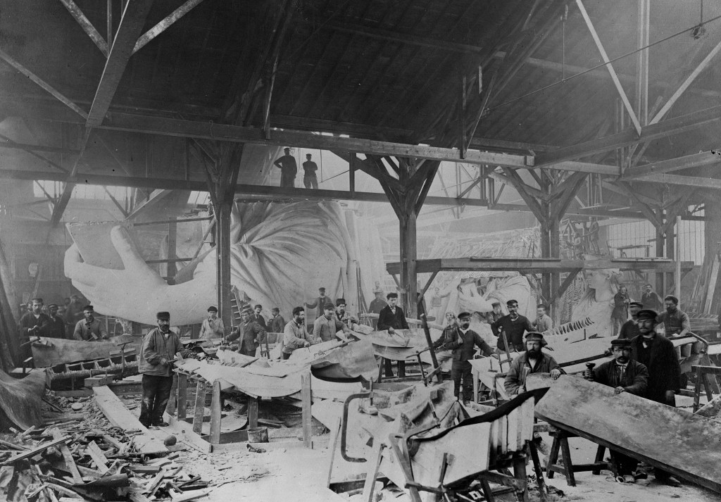 Workmen constructing the Statue of Liberty, hammering copper, with left hand and head in background, at the Gaget, Gauthier & Co. workshop in Paris, 1881-1883