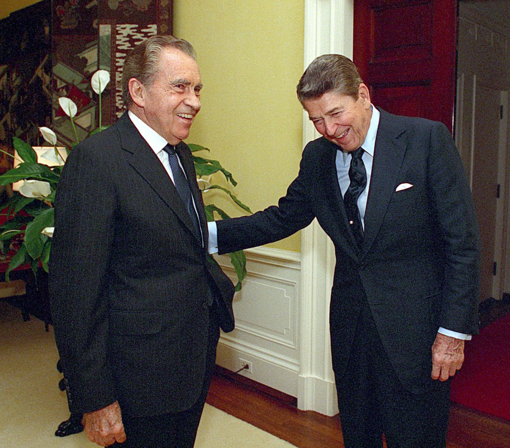 Ronald Reagan standing with his arm on Richard Nixon photograph on July 28th, 1988. Both had a Presidential election in which they won 49 states.