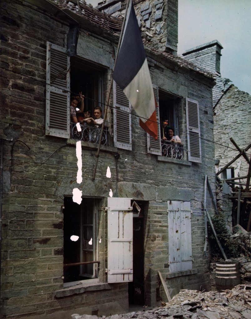 Happy French civilians return to their homes in liberated Cherbourg, France, and start the task of clearing the debris caused by heavy artillery fire and aerial attacks.

original color photo from the 1940s